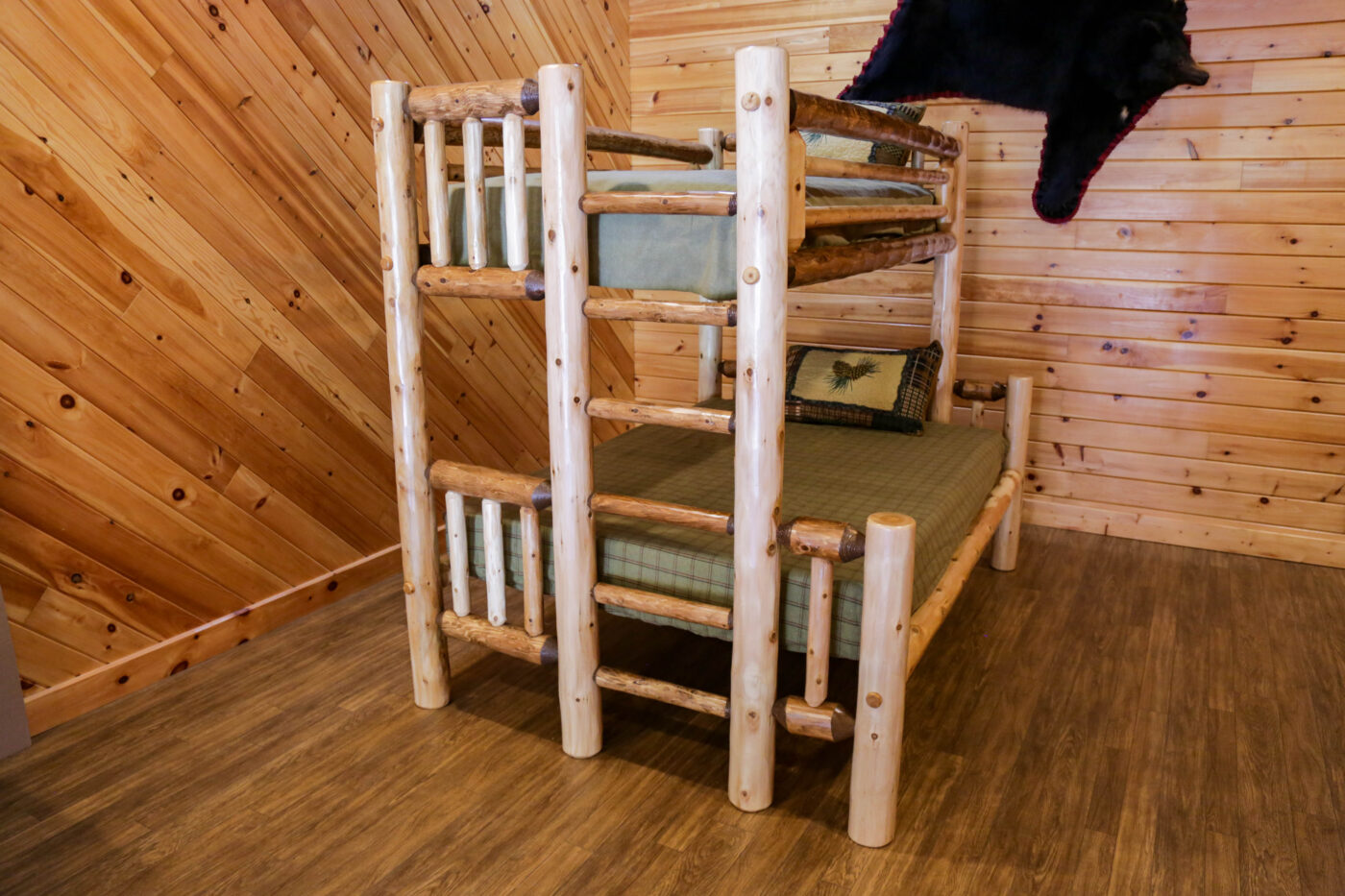 Two Tone cedar Rustic log-style bunk bed with a twin-over-full design, handcrafted from natural wood, in a cozy cabin setting.